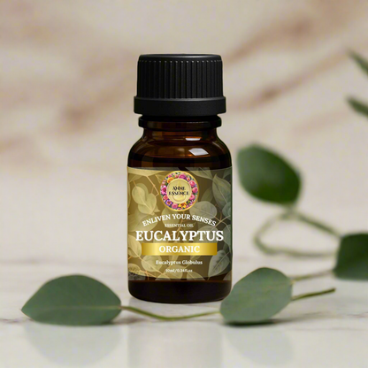 Bottle of Anne Essence Organic Eucalyptus Essential Oil on a marble surface with blurred green eucalyptus leaves in a luxury studio background