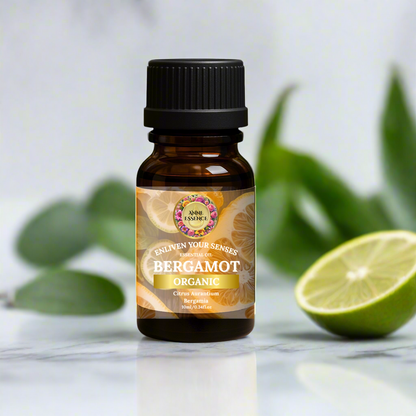 Elegant bottle of Organic Bergamot Essential Oil from Anne Essence placed on a smooth white marble background with fresh lime and green leaves, representing purity, freshness, and citrus vitality.